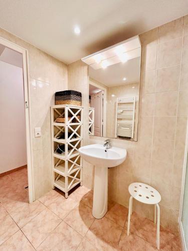 La salle de bains est pourvue d'un lavabo et d'une étagère avec des bouteilles de vin. dans l'établissement Riviera Mornings - Old Town Stay - 5 Min to Beach & Breakfast, à Villefranche-sur-Mer