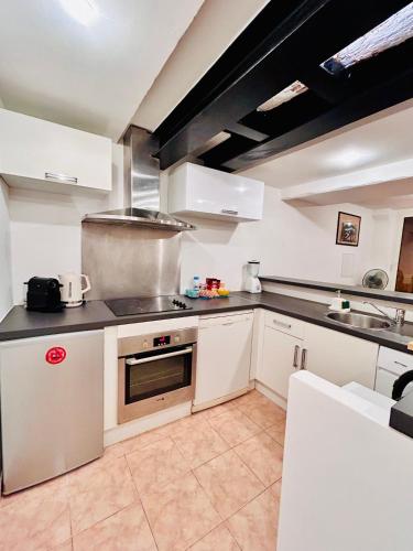 une cuisine avec des armoires blanches et un four à plaques de cuisson dans l'établissement Riviera Mornings - Old Town Stay - 5 Min to Beach & Breakfast, à Villefranche-sur-Mer