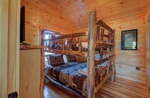 a bedroom with two bunk beds in a log cabin at Pebblestone Lodge in Pigeon Forge