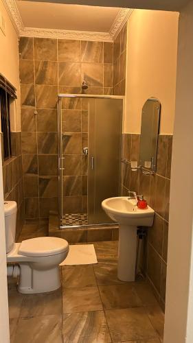 a bathroom with a toilet and a sink and a shower at The86thGuest Krugersdorp in Krugersdorp