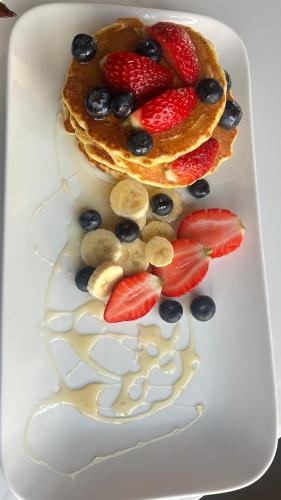 a plate with pancakes with strawberries and blueberries at The86thGuest Krugersdorp in Krugersdorp