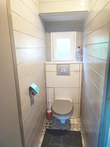 Elle comprend une petite salle de bains pourvue de toilettes et d'une fenêtre. dans l'établissement Chalet cosy 300 mètres du lac, à Margencel