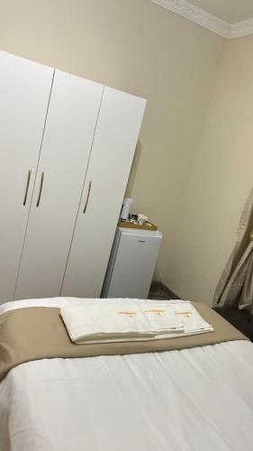 a bedroom with white cabinets and a white bed at The86thGuest Krugersdorp in Krugersdorp