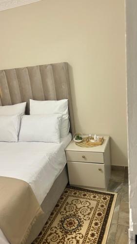 a bed with white pillows and a night stand with a nightstand at The86thGuest Krugersdorp in Krugersdorp