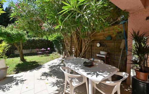 une table et des chaises dans un jardin avec des plantes dans l'établissement 1 Bedroom Amazing Apartment In Lunel, à Lunel