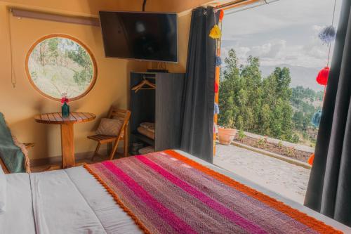 a bedroom with a bed and a window with a view at Altipacha Valley Q Lodge in Quinua