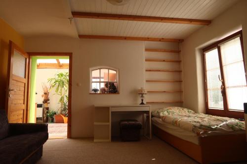 a bedroom with a bed and a desk and a mirror at Guest House Relax in Březí