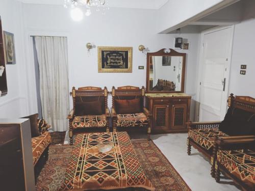a living room with two chairs and a mirror at Tata house in Cairo