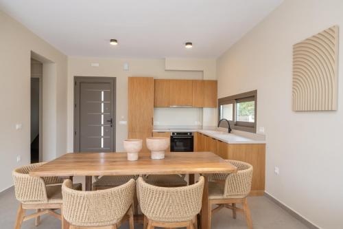 a kitchen with a wooden table and chairs at Memorial Villa Pessada in Pesádha