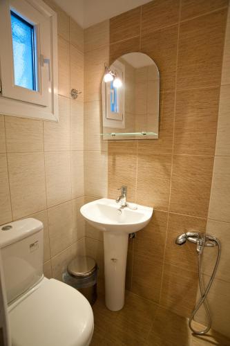 a bathroom with a toilet and a sink and a mirror at Hercules in Amaliápoli