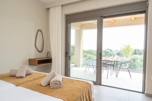 a bedroom with a bed and a sliding glass door at Memorial Villa Pessada in Pesádha