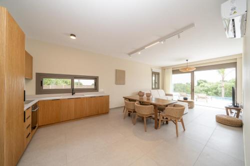 a kitchen and dining room with a table and chairs at Memorial Villa Pessada in Pesádha