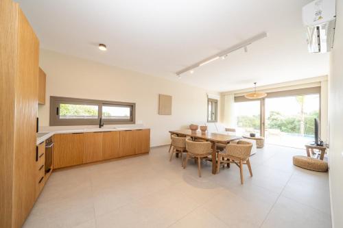 a kitchen and dining room with a table and chairs at Memorial Villa Pessada in Pesádha