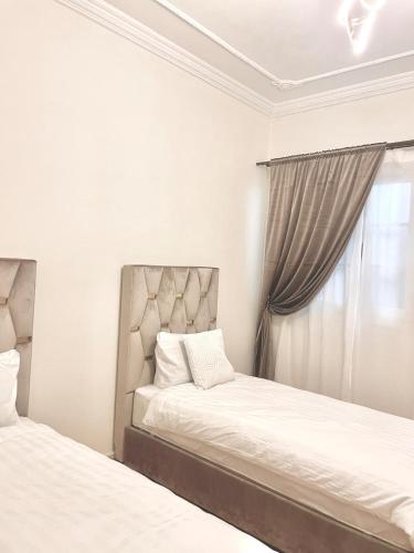 a bedroom with two beds and a window at Apartment 5 min Corniche in Nador