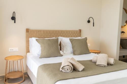 a bedroom with a bed with towels on it at Memorial Villa Pessada in Pesádha
