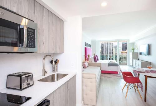 a kitchen with a sink and a living room at MVR - Wake to Sunrises Toast to Sunsets in Miami