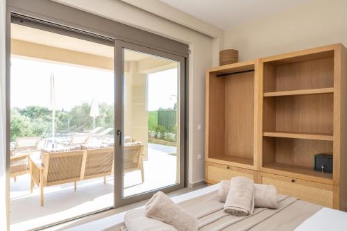 a bedroom with a sliding glass door with a view of a patio at Memorial Villa Pessada in Pesádha