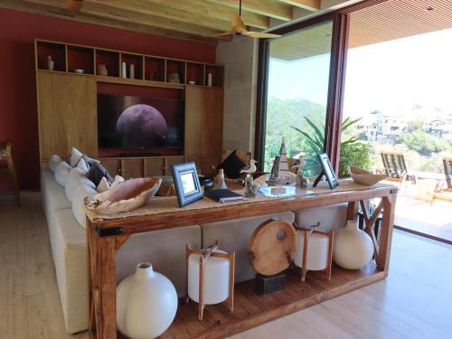 a room with a table with vases and a tv at Casa Sirenas - Paradise in Puerto Vallarta in Cruz de Huanacaxtle