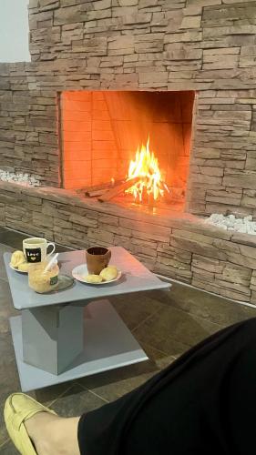a table with two cups of coffee and a fireplace at Hotel Las Piedras San Jose in San José de Isnos