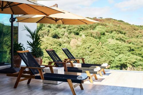 a group of chairs and an umbrella on a patio at Casa Sirenas - Paradise in Puerto Vallarta in Cruz de Huanacaxtle