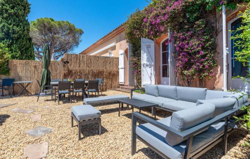 un patio avec un canapé, des tables et des chaises dans l'établissement Amazing Home In Saint-Raphaël, à Saint-Raphaël