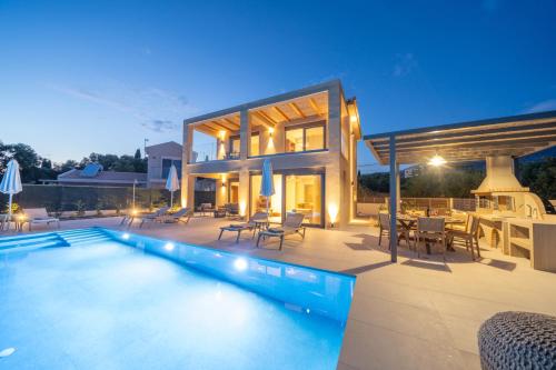a house with a swimming pool in front of a house at Memorial Villa Pessada in Pesádha