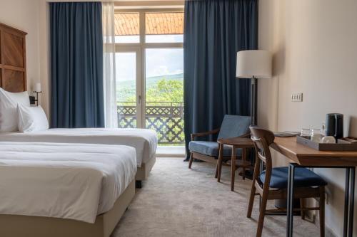 a hotel room with two beds and a desk and a window at AGARANI Estate in Tʼelavi