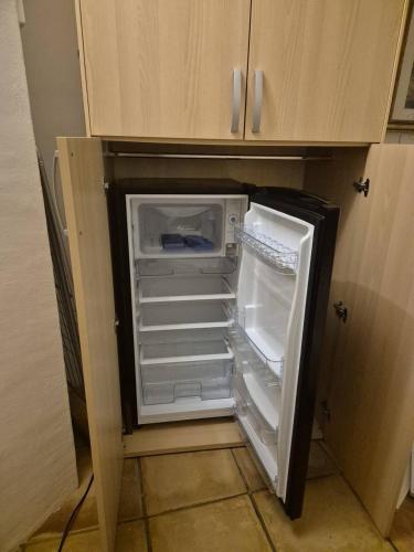 an empty refrigerator with its door open in a kitchen at Casa Alessandra, Apartment in Porto Cervo in Porto Cervo