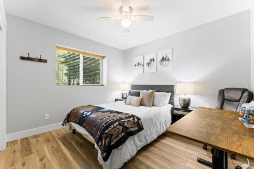 a white bedroom with a bed and a table at Pineview on Baycolt- remodeled w/great parking, near downtown and golf course in McCall