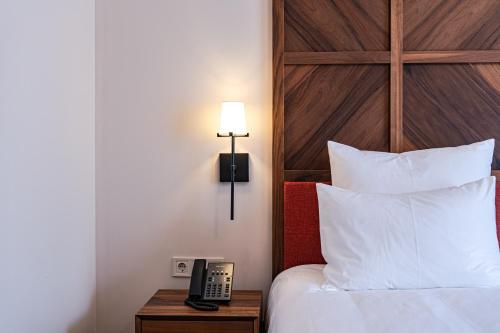 a hotel room with a bed and a phone on a table at AGARANI Estate in Tʼelavi