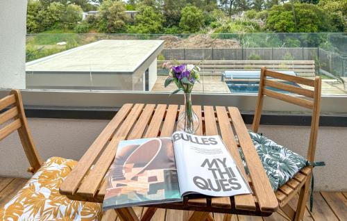 une table en bois avec un vase de fleurs et un magazine dans l'établissement Cozy Home In Saint Jean De Monts, à Saint-Jean-de-Monts