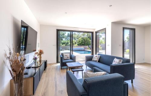 - un salon avec des canapés bleus et une piscine dans l'établissement Cozy Home In Saint Jean De Monts, à Saint-Jean-de-Monts