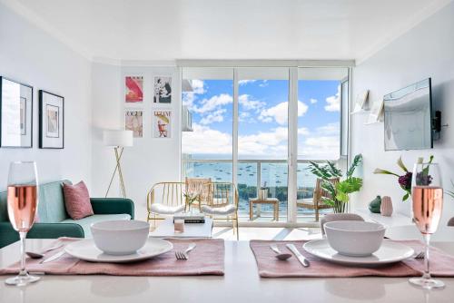 a living room with a table with plates and wine glasses at MVR - Elevate Your Stay with Stunning Ocean Views in Miami