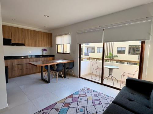 a kitchen and living room with a table and chairs at Fantástico Depa en Cerritos OCEANNA frente al MAR ! - 237 AB - in Mazatlán