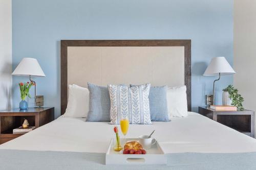 a white bed with a tray of fruit on it at MVR - Sunsets So Good You-ll Book Twice in Miami