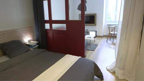 um quarto com uma cama e uma porta vermelha em Les Rochelais 12B em La Rochelle