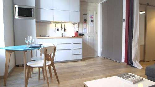 une petite cuisine avec une table et des chaises dans une pièce dans l'établissement Les Rochelais 12B, à La Rochelle