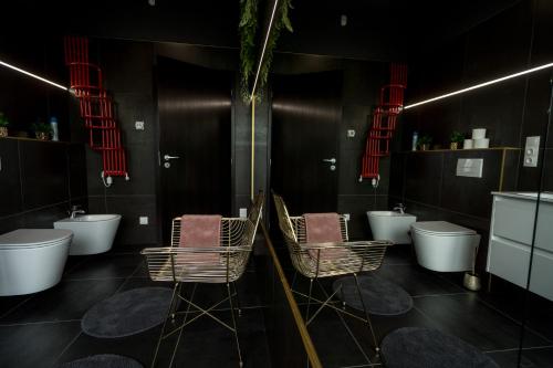 a bathroom with three sinks and three chairs in it at Bella in Óhid