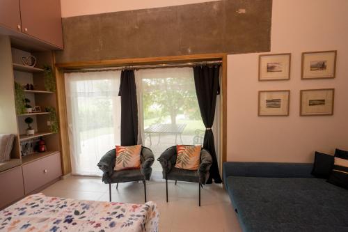 a bedroom with a bed and two chairs and a window at Bella in Óhid