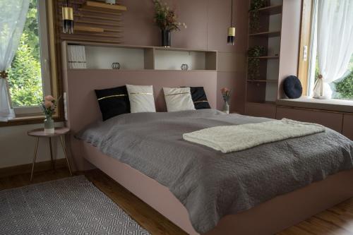 a bedroom with a large bed in a room with windows at Bella in Óhid