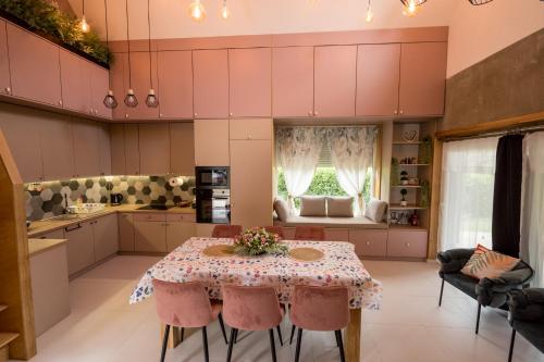 a kitchen with a table with pink chairs at Bella in Óhid