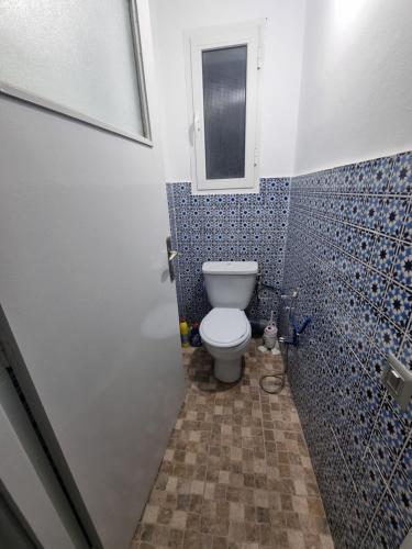a bathroom with a toilet and a window in it at Bel appartement face à la méditerranée in Bizerte