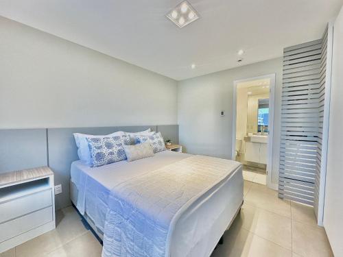 a bedroom with a bed with blue and white pillows at São Paulo Ibirapuera Convention Plaza 02 Banheiros in São Paulo