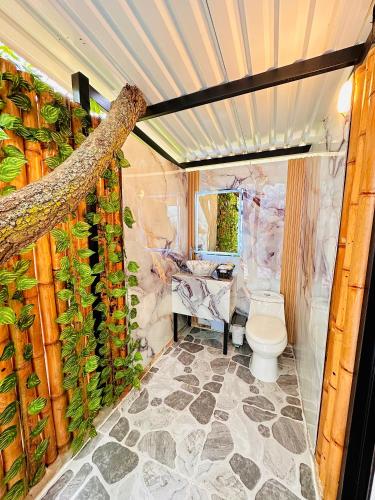a bathroom with a toilet and a plant wall at Glamping Girardot & Hotel Puerta Del Sol Girardot in La Virginia