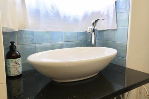 a white bowl sink on a counter in a bathroom at Casinha Das Portas in Castelo Bom
