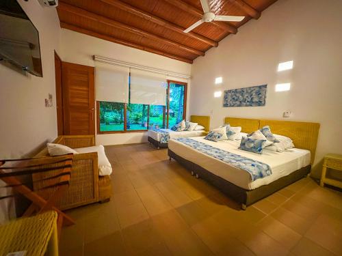 a bedroom with two beds and a couch in it at Hotel Chiniu in Palomino