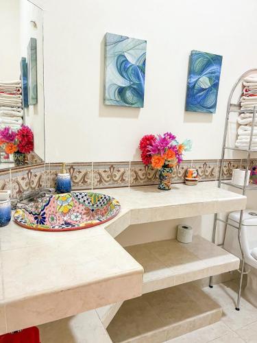 a counter with a plate and flowers on it at Troy's House in Cozumel