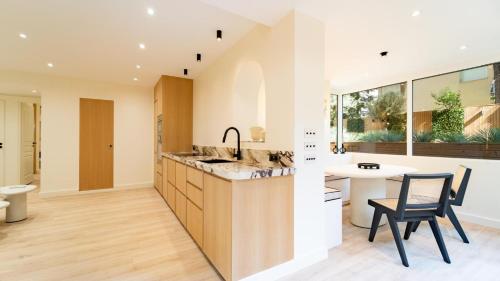 une cuisine avec un comptoir, une table et des chaises dans l'établissement Cocoon in Cannes Martinez, à Cannes