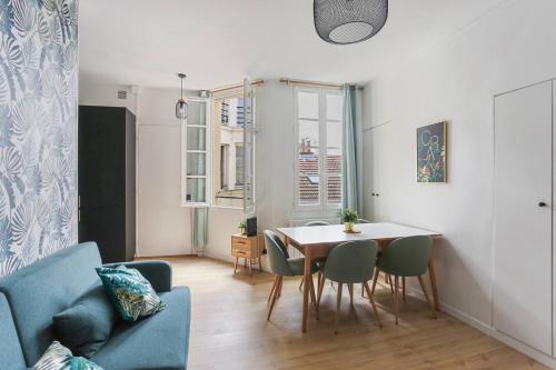 un salon avec une table et un canapé bleu dans l'établissement Le Baron - Versailles, à Versailles