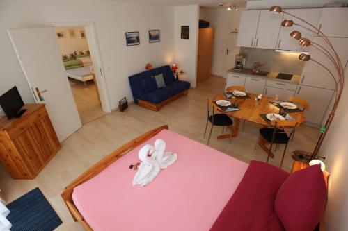 a living room and a kitchen with a pink table at Ferienwohnung Schwarzwald Oase - Todtmoos - Mein Schwarzwaldhäusle in Todtmoos